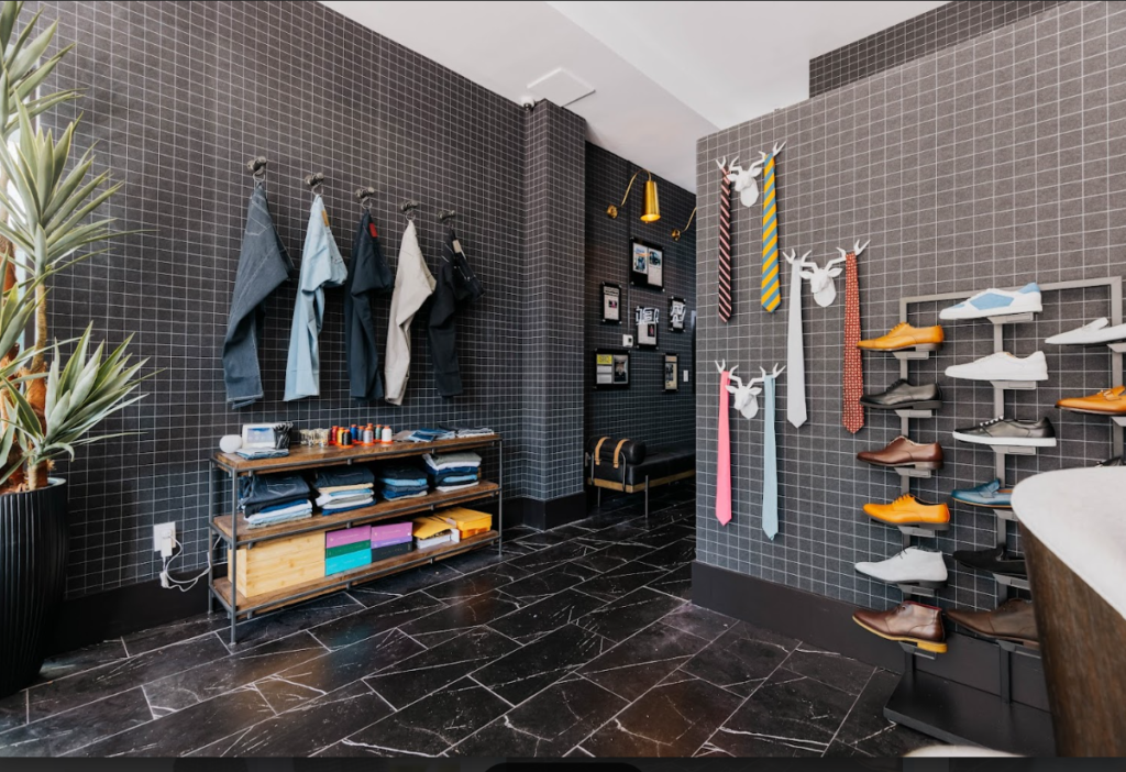 A close-up shot of a person adjusted their collar with a small, confident smile, wearing high-quality fabric that looks both stylish and cozy.